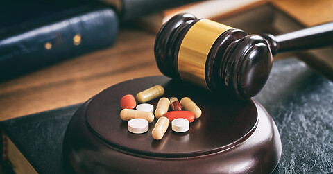 Judge gavel and drugs on a wooden desk