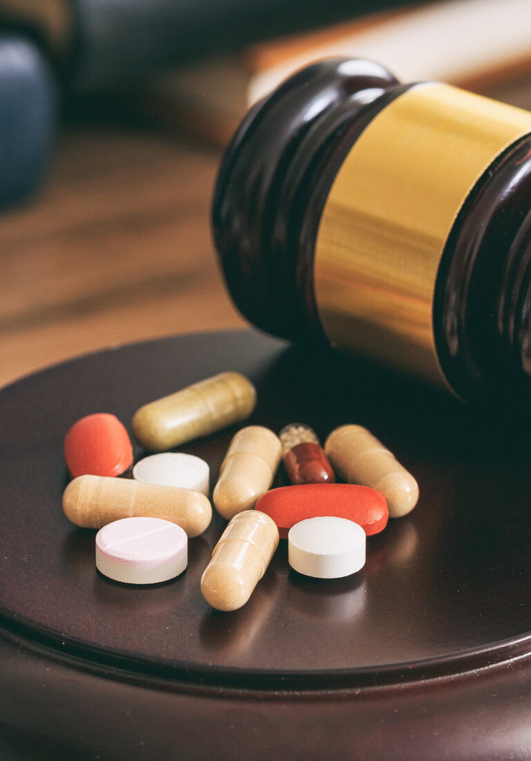 Judge gavel and drugs on a wooden desk