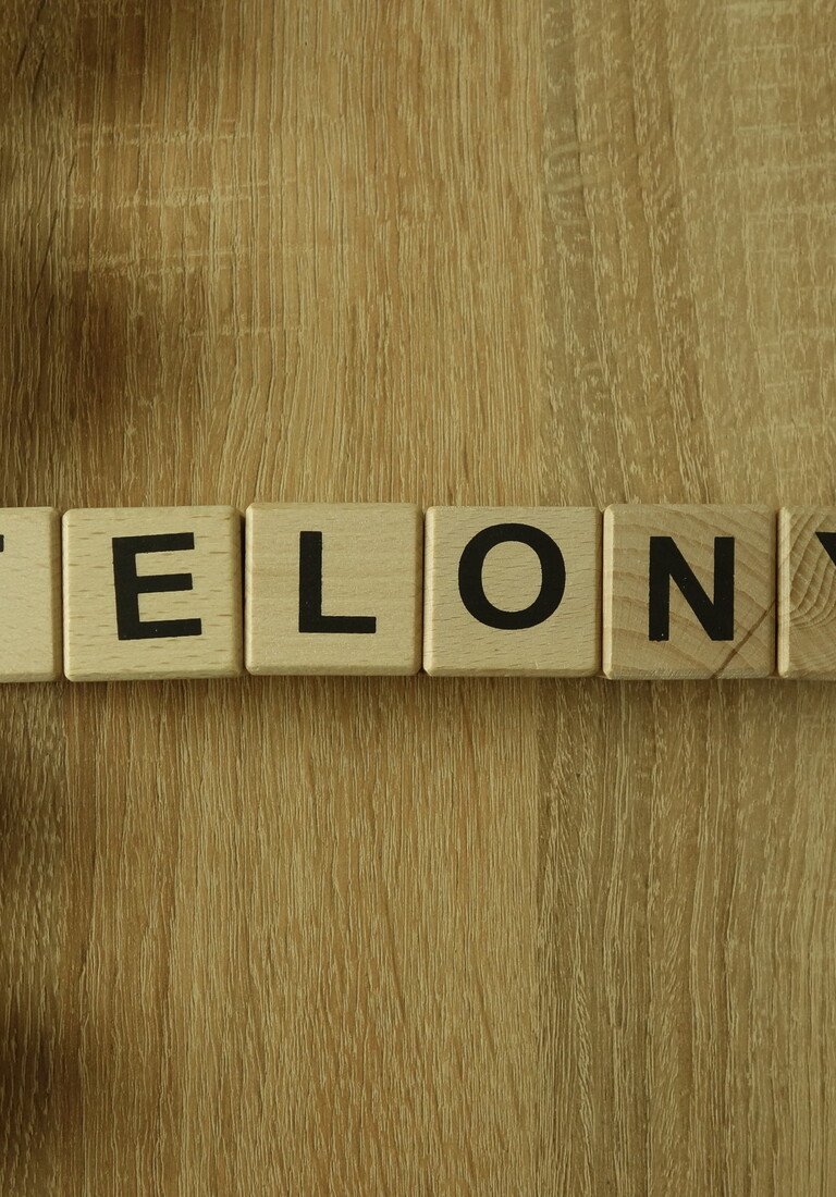 Felony word from wooden blocks on desk
