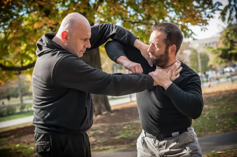 Two men engage in a physical altercation in a park, illustrating a real-world example relevant to assault and battery charges in Kansas.