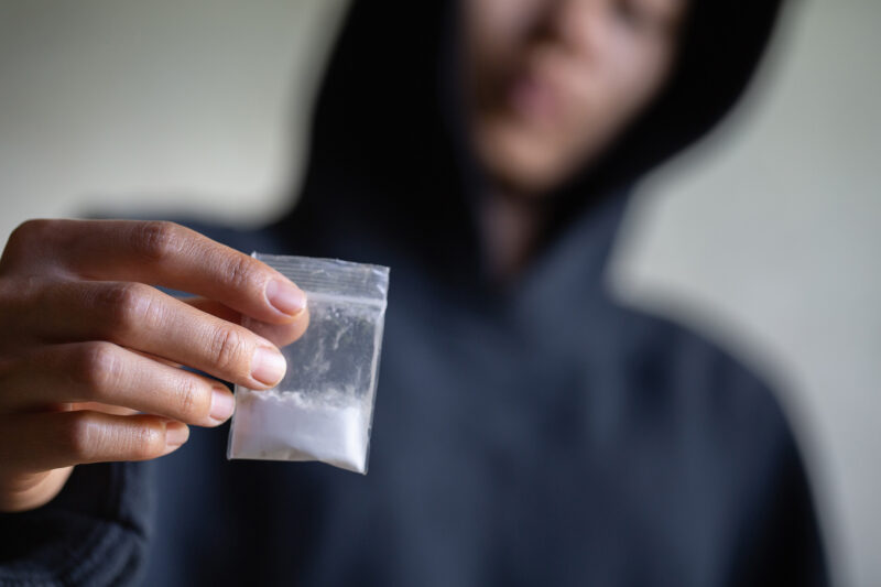 Drug dealer holding up bag of powdered drugs. If you’ve been charged with a drug crime in Overland Park or Olathe, our drug crime lawyers will fight to keep your freedom. Contact our attorneys now.