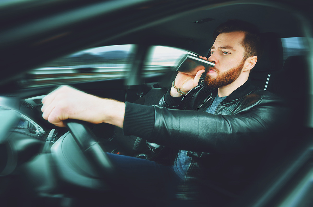 Drunk driver drinking out of flask. If you’ve been charged with a DUI or DWI in Johnson County, contact our Olathe DUI lawyers now.