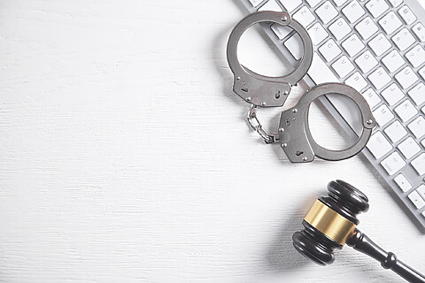 Pair of handcuffs and judge gavel representing criminal defense. Our criminal defense lawyers fight for those charged with crimes in Johnson County.