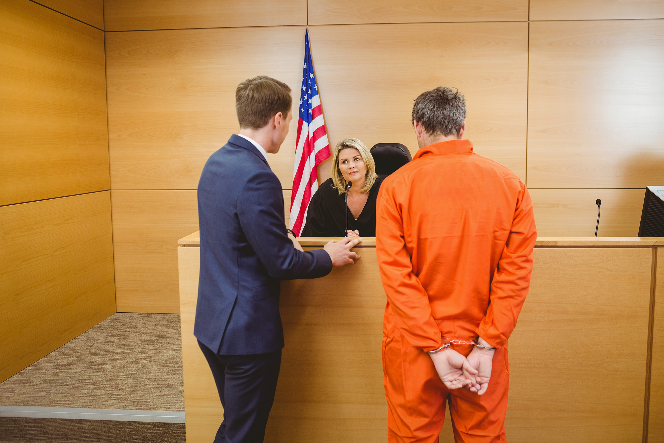 Criminal defense lawyer and detained criminal talking to female judge. At Henderson Legal Defense, LLC, we represent clients charged with a wide range of felony and misdemeanor crimes.