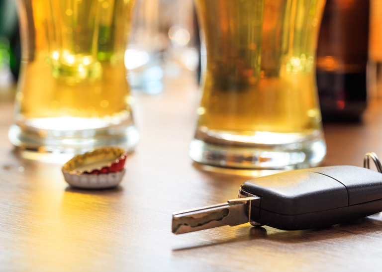 Glasses of beer on a table next to a car key.