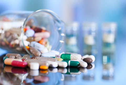 A jar of multi-colored pills knocked over and spilling out.