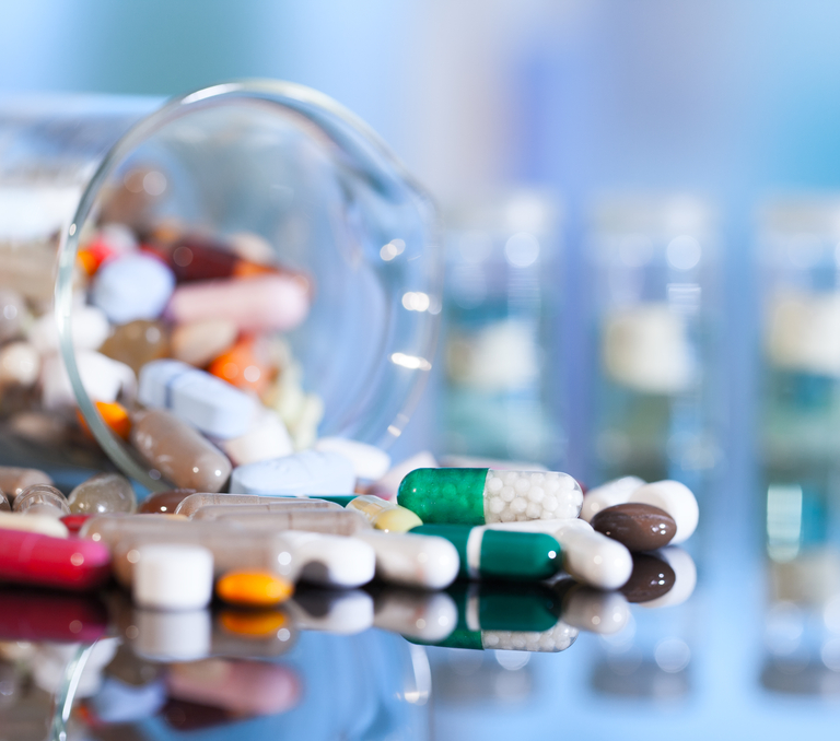 A jar of multi-colored pills knocked over and spilling out.