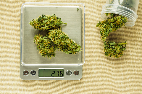 Cannabis in a jar and on a scale.