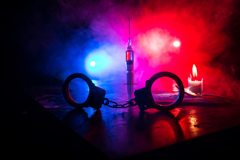 Handcuffs in police lights.