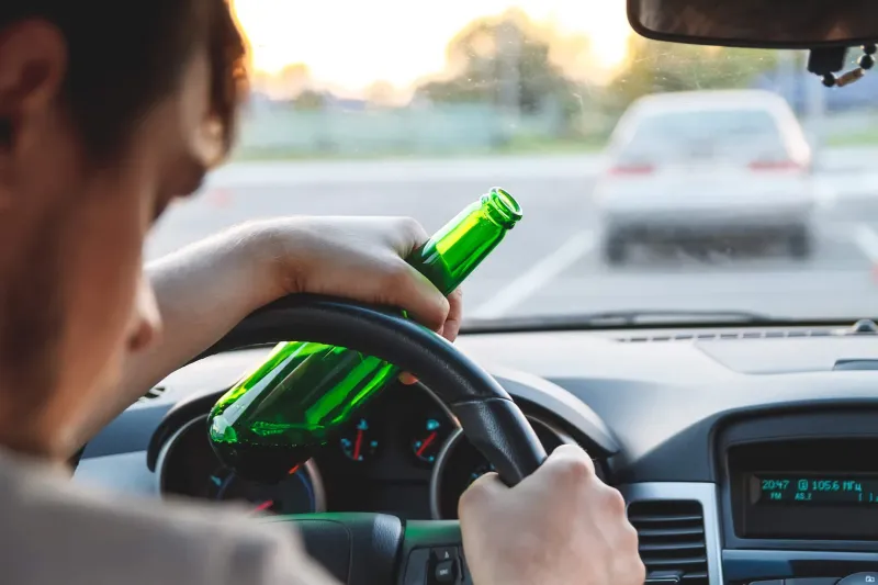 A person drinking and driving behind the wheel.